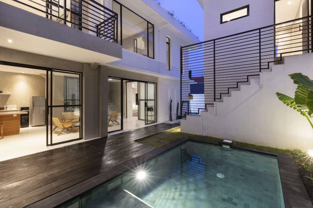 Villa de lujo al atardecer con piscina iluminada
